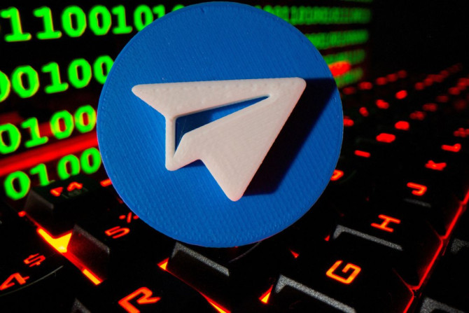 Un logo Telegram imprimé en 3D est représenté sur un clavier devant un code binaire dans cette illustration prise le 24 septembre 2021.