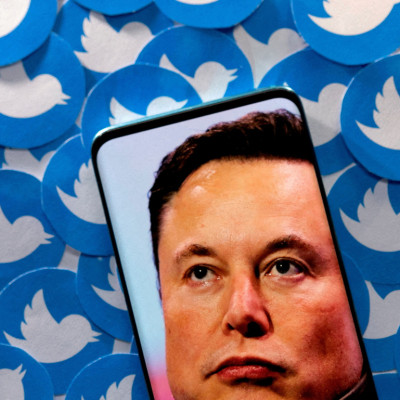 L&#39;illustration montre l&#39;image d&#39;Elon Musk sur un smartphone et les logos Twitter imprimés
