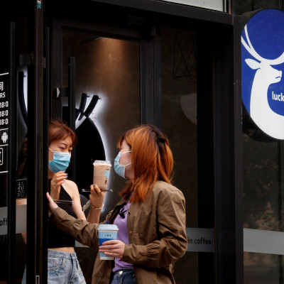 Des femmes quittent un magasin de la chaîne de cafés chinois Luckin Coffee à Pékin