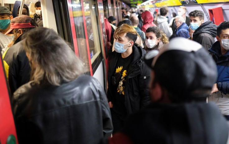 Les navetteurs attendent le train à la station de métro au milieu de l&#39;épidémie de la maladie à coronavirus (COVID-19) à Barcelone, Espagne, le 12 janvier 2022.