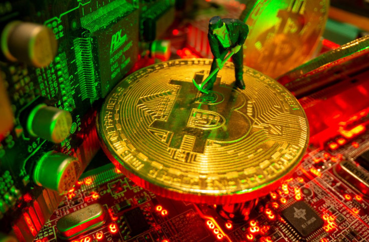 Une petite figurine et des représentations de la monnaie virtuelle bitcoin se tiennent sur une carte mère dans cette illustration prise le 20 mai 2021.