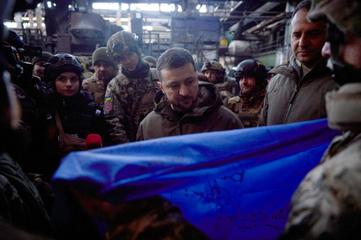 Le président ukrainien Volodymyr Zelensky reçoit un drapeau ukrainien portant les signatures des soldats lors d&#39;une visite dans la ville de première ligne de Bakhmut