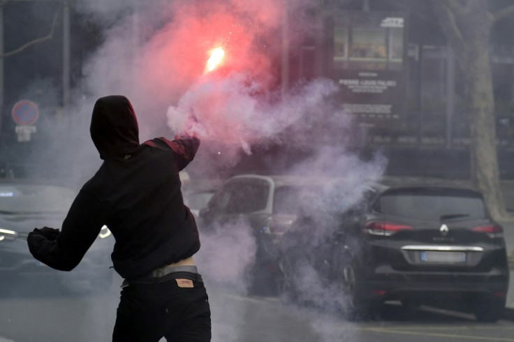 Un homme lance une fusée éclairante sur la police jeudi à Paris, mais les manifestations ont été extrêmement pacifiques