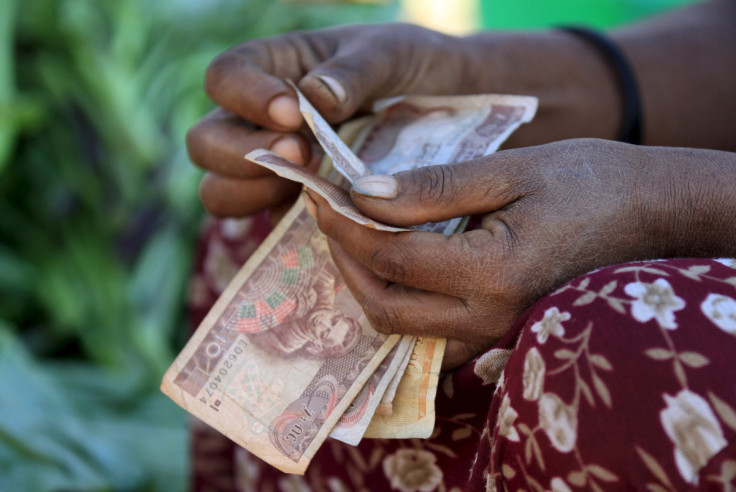 Une femme compte des billets de birr éthiopiens après avoir vendu un chou au marché Mercato à Addis-Abeba