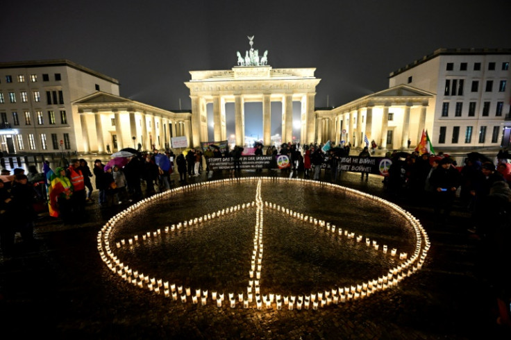 Un signe de paix géant est formé avec des bougies devant la porte de Brandebourg à Berlin