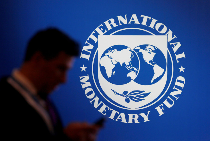 Un participant se tient près d&#39;un logo du FMI au Fonds monétaire international - Assemblée annuelle de la Banque mondiale 2018 à Nusa Dua