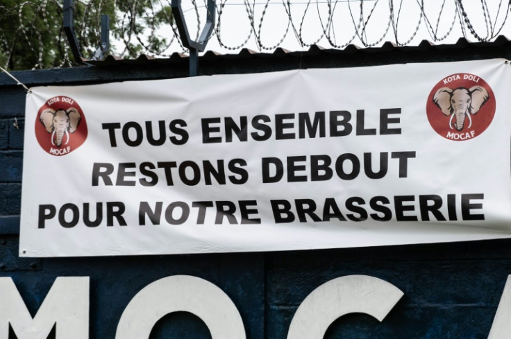Un panneau sur la clôture de la brasserie dit "Soyons tous solidaires pour notre brasserie"