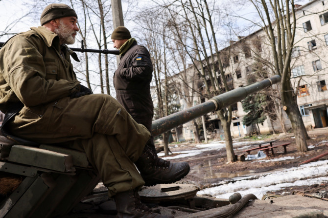 Des militaires ukrainiens se tiennent au sommet d&#39;un char, près de la ville orientale bombardée de Bakhmut