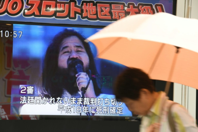 Un piéton passe devant un écran clignotant des nouvelles sur l&#39;exécution de Shoko Asahara, le chef de la secte Aum Shinrikyo, à Tokyo le 6 juillet 2018. Shoko Asahara, le chef de la secte Aum Shinrikyo qui a mené une attaque mortelle au sarin sur Toky