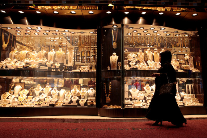 Une femme passe devant des bijoux en or affichés dans une vitrine au Gold Souq de Dubaï