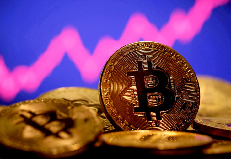 Une représentation de la monnaie virtuelle Bitcoin est visible devant un graphique boursier dans cette illustration prise