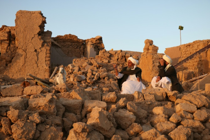 Des Afghans sont assis dans les décombres de leurs maisons détruites dans le village de Sarbuland, dans la province d&#39;Herat, à la suite du tremblement de terre de samedi.