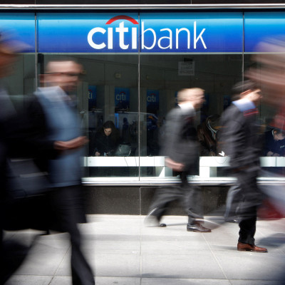 Des gens passent devant une succursale de la CitiBank sur Avenue of the Americas, à New York.