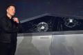 Le co-fondateur et PDG de Tesla, Elon Musk, réagit verbalement devant le nouveau Tesla Cybertruck entièrement électrique alimenté par batterie avec des vitres brisées à la suite d&#39;une manifestation qui ne s&#39;est pas déroulée comme prévu le 21 novem