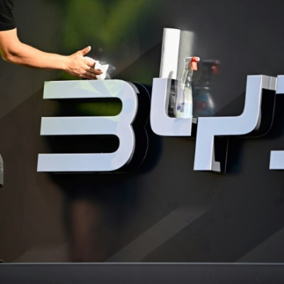 Un ouvrier nettoie le logo de l&#39;entreprise du constructeur automobile chinois BYD sur son stand avant le lancement officiel du Salon international de l&#39;automobile (IAA) au centre de Munich, dans le sud de l&#39;Allemagne, le 4 septembre 2023.