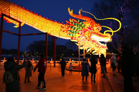 Les gens se rassemblent pour observer une figure de dragon géant dans un parc de Pékin le 9 février 2024, qui marque la veille du Nouvel An lunaire du Dragon.