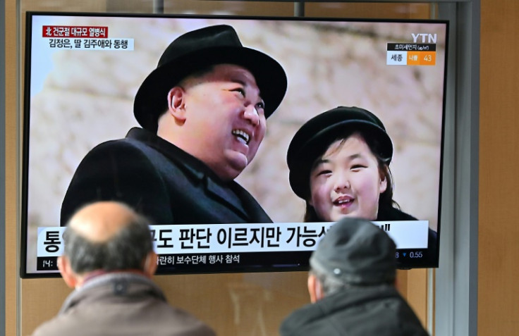 Les gens regardent un écran de télévision diffusant un journal télévisé avec une image de Kim Jong Un et de sa fille Ju Ae