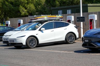 white Tesla surfboards roof parked parking lot