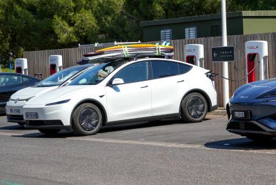 white Tesla surfboards roof parked parking lot